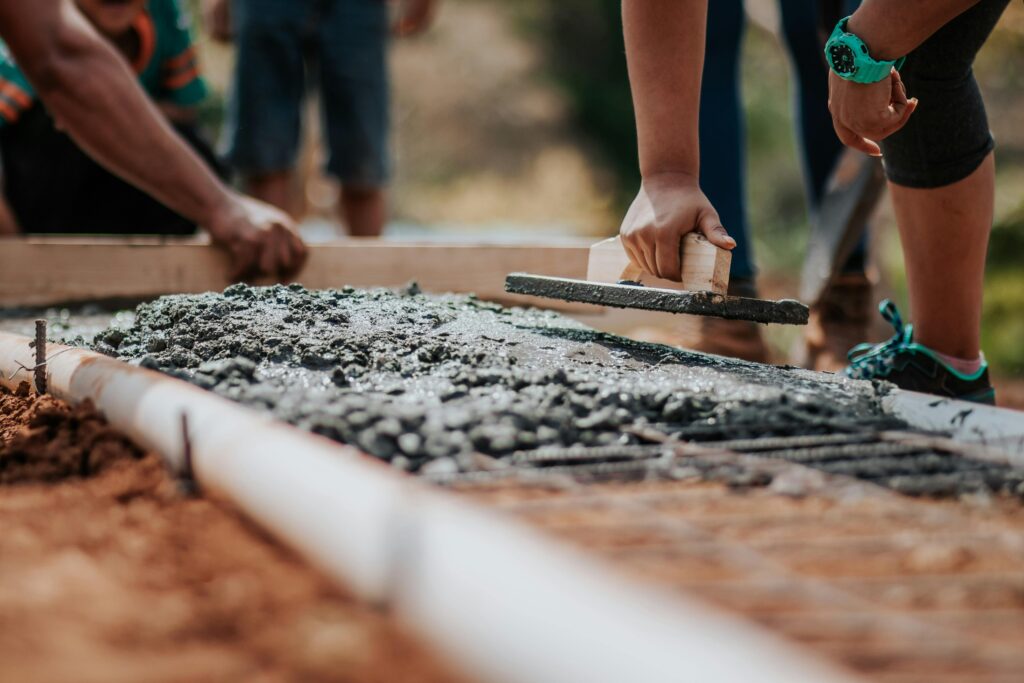 Aplicació manual de formigó fresc en una obra de construcció a Osona o el Ripollès