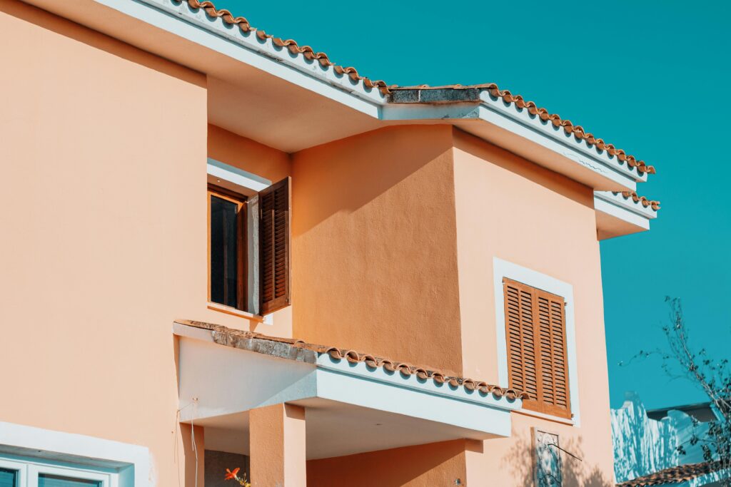 Fachada de casa con revestimientos y materiales de construcción de calidad bajo un cielo despejado, representando los productos disponibles en Euromat Manlleu.