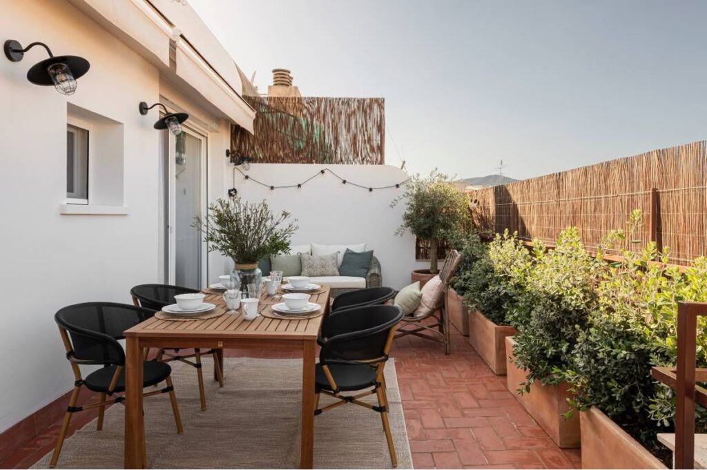 Terraza reformada con comedor exterior, plantas y muebles de madera: un espacio acogedor y funcional para disfrutar al aire libre