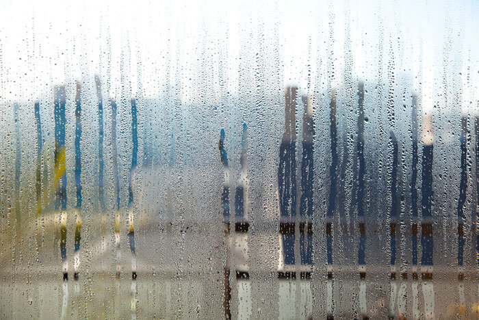 Cristal de ventana con condensación y gotas de agua debido a la humedad interior en una vivienda